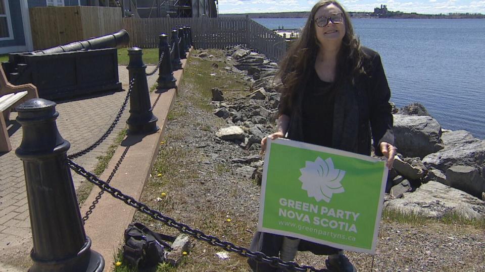 Pictou West Green Party candidate Clare Brett puts up a campaign sign on Tuesday. 