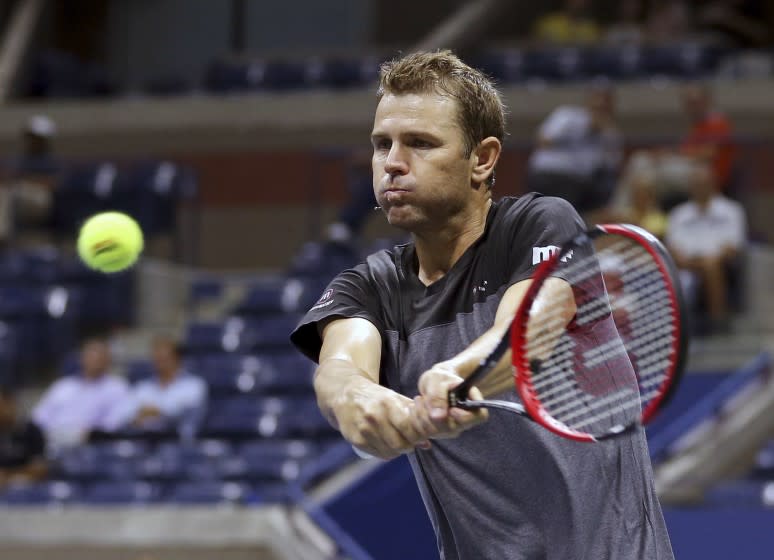Mardy Fish hits a return as he and Jim Courier played Michael Chang and John McEnroe.