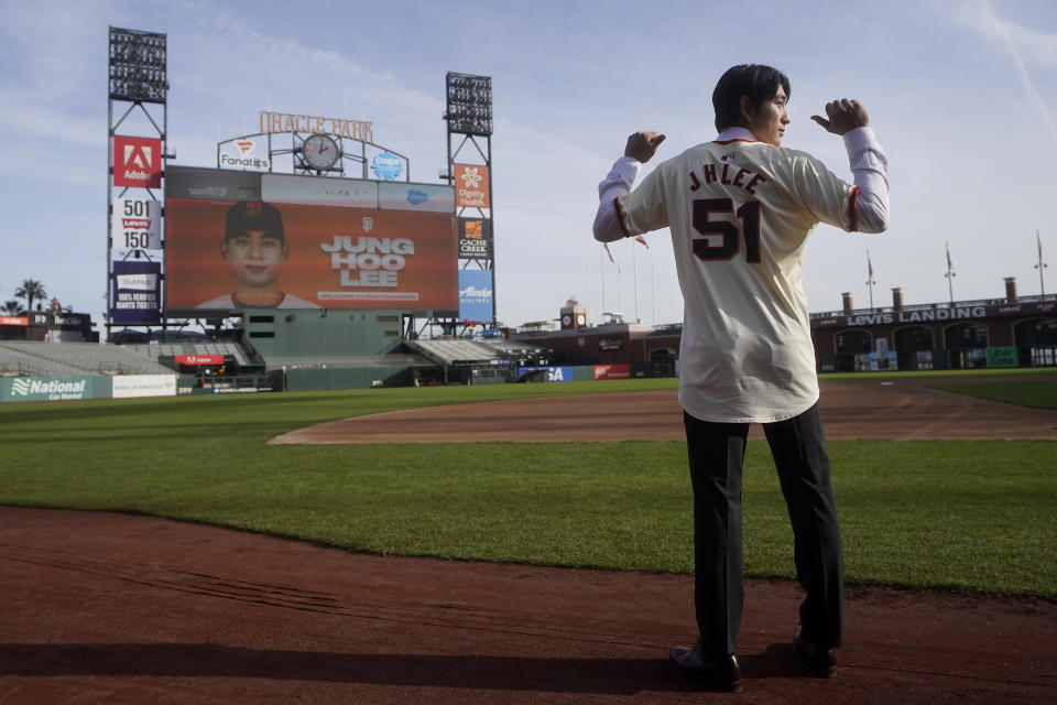 San Francisco Giants' Jung Hoo Lee poses for photos on the field at Oracle Park after a baseball news conference in San Francisco, Friday, Dec. 15, 2023. (AP Photo/Jeff Chiu)