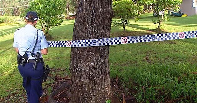 Police officers tape off a property being searched.