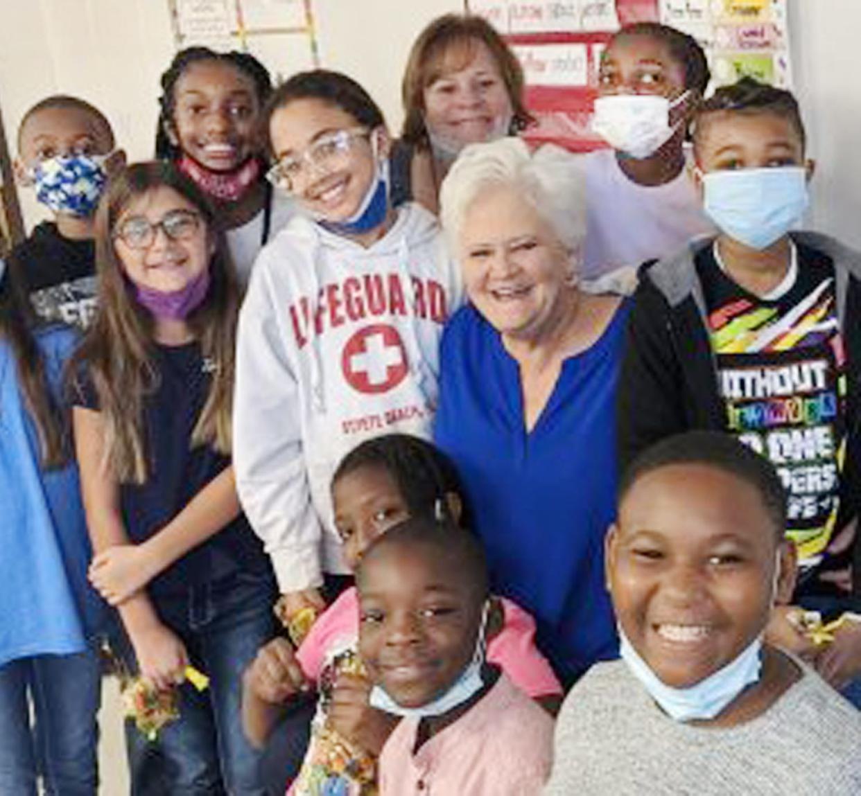 Jefferson County Superintendent of Schools Dr. Molly Howard poses with Louisville Academy students after reading to their class.