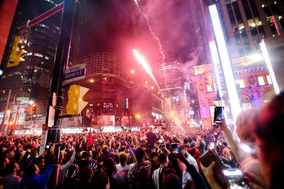 Thousands of fans celebrate in the streets of Toronto after the Toronto Raptors defeated the Golden State Warriors 114-110 during Game 6 of basketball's NBA Finals in Oakland, Calif., to win the league title, early Friday, June 14, 2019. (Nathan Denette/The Canadian Press via AP)