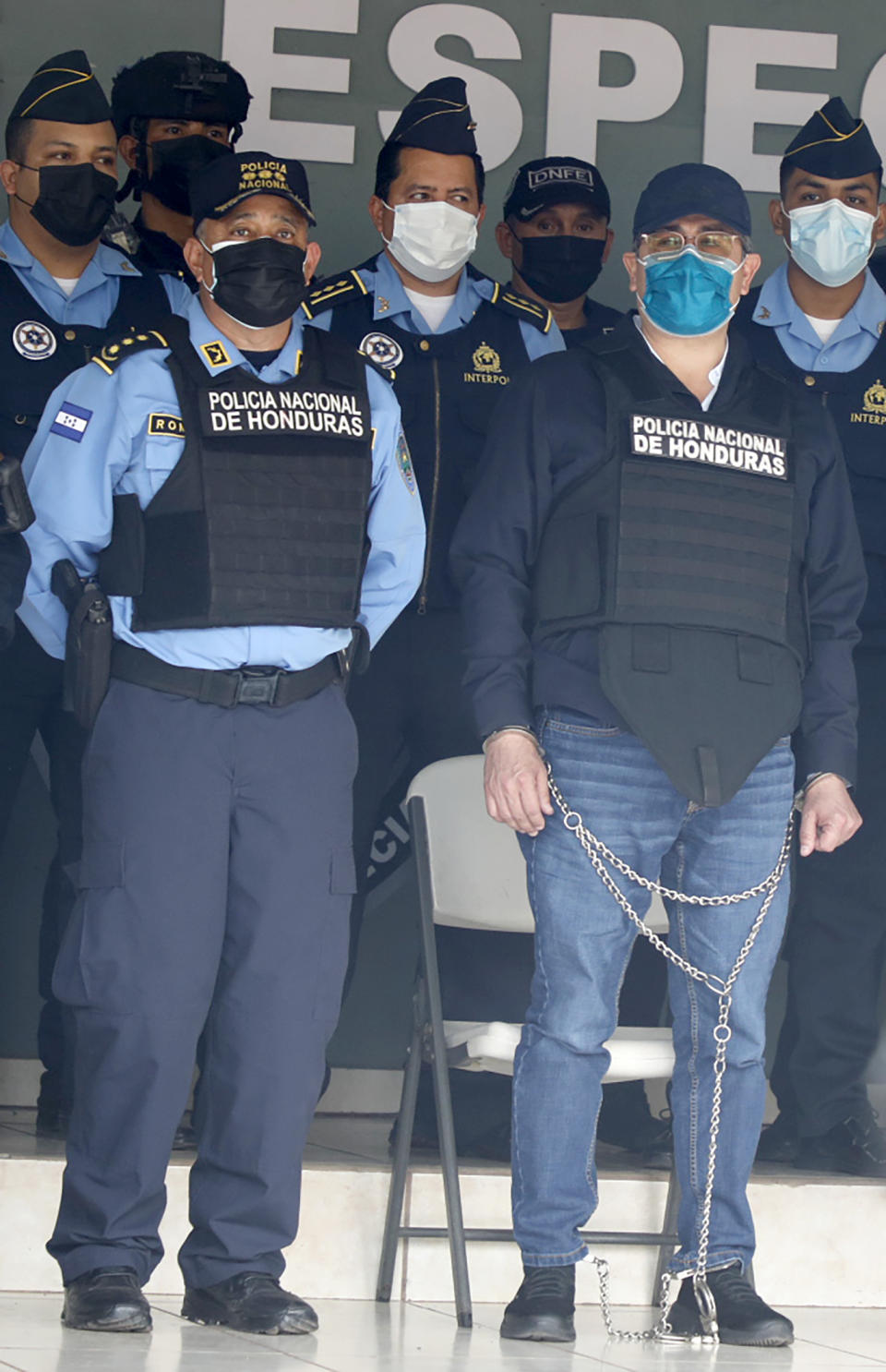 Former Honduran President Juan Orlando Hernandez, in chains, is shown to the press at the Police Headquarters in Tegucigalpa, Honduras, Tuesday, Feb. 15, 2022. Police arrested Hernandez at his home, following a request by the United States government for his extradition on drug trafficking and weapons charges. (AP Photo/ Elmer Martinez)