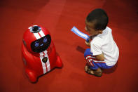 <p>Auf der „Welt Roboter Konferenz“ in Peking staunt ein Junge über die Motorik eines selbstfahrenden Roboters. (Bild: AP Photo/Andy Wong) </p>
