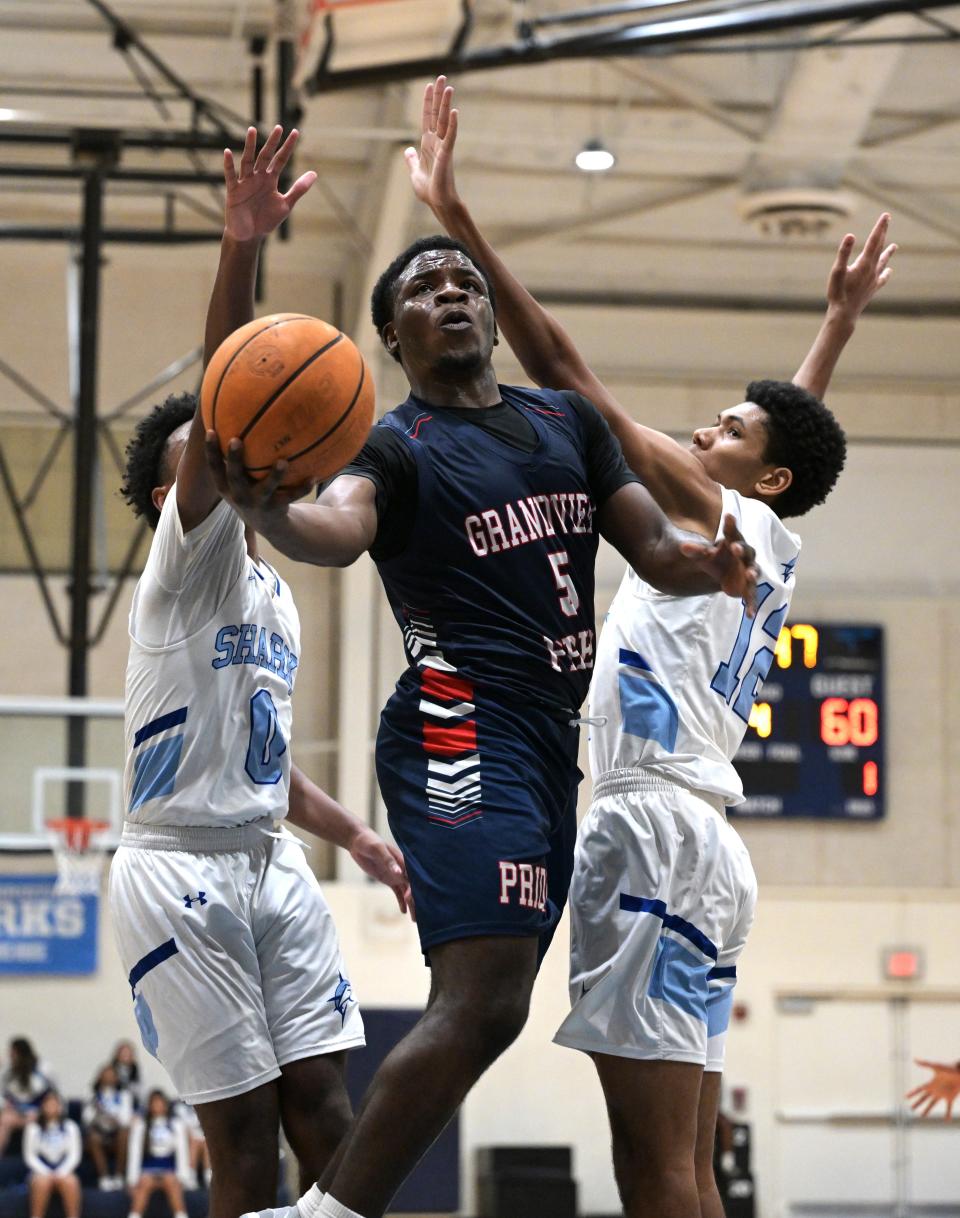 Grandview Prep's Marco Jardonne splits two Atlantic Christian defenders as he goes up for a layup on Feb. 15, 2024.