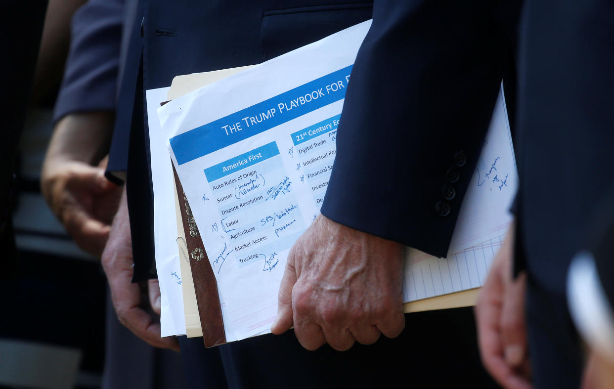 U.S. Trade Representative Robert Lighthizer holds a “Trump Playbook” document as he stands behind U.S. President Donald Trump as the president announces the United States-Mexico-Canada Agreement (USMCA) during a news conference in the Rose Garden of the White House in Washington, U.S., October 1, 2018. REUTERS/Leah Millis