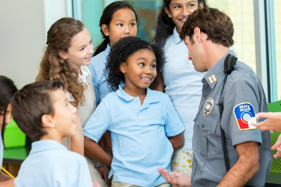 <span class="caption">The image police project in schools doesn’t always mirror reality.</span> <span class="attribution"><a class="link " href="https://www.gettyimages.com/detail/photo/elementary-school-student-asks-policeman-a-question-royalty-free-image/596374182" rel="nofollow noopener" target="_blank" data-ylk="slk:SDI Productions;elm:context_link;itc:0;sec:content-canvas">SDI Productions</a></span>