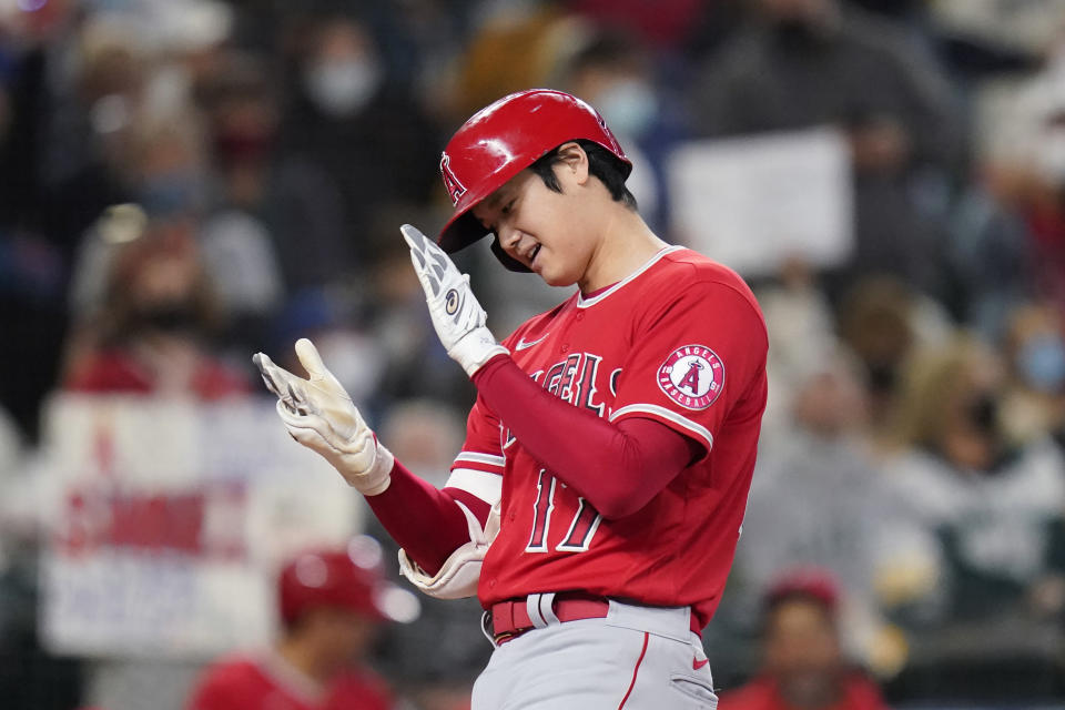 Los Angeles Angels' Shohei Ohtani claps his hands together as he crosses home on his solo home run against the Seattle Mariners in the first inning of a baseball game Sunday, Oct. 3, 2021, in Seattle. (AP Photo/Elaine Thompson)