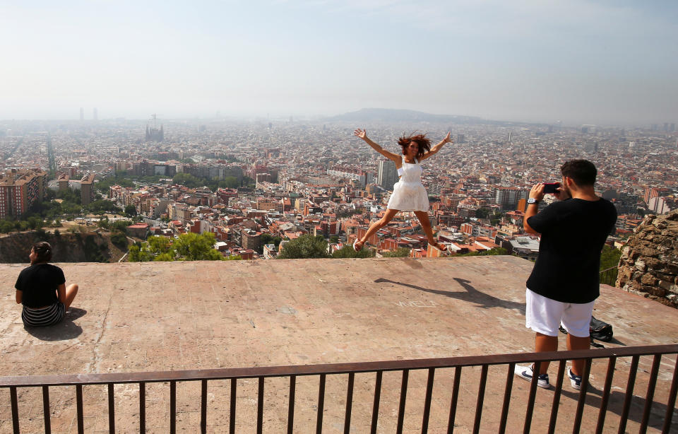 Turistas hacen fotos con Barcelona al fondo. REUTERS/Albert Gea