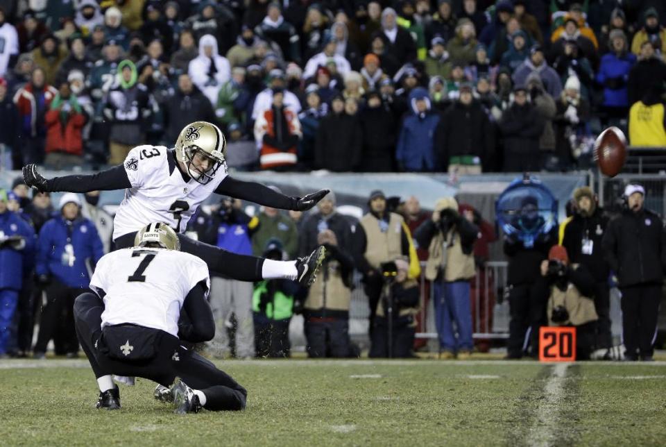 New Orleans Saints' Shayne Graham kicks the game-winning field goal in front of teammate Luke McCown during the second half of an NFL wild-card playoff football game against the Philadelphia Eagles, Saturday, Jan. 4, 2014, in Philadelphia. (AP Photo/Matt Rourke)