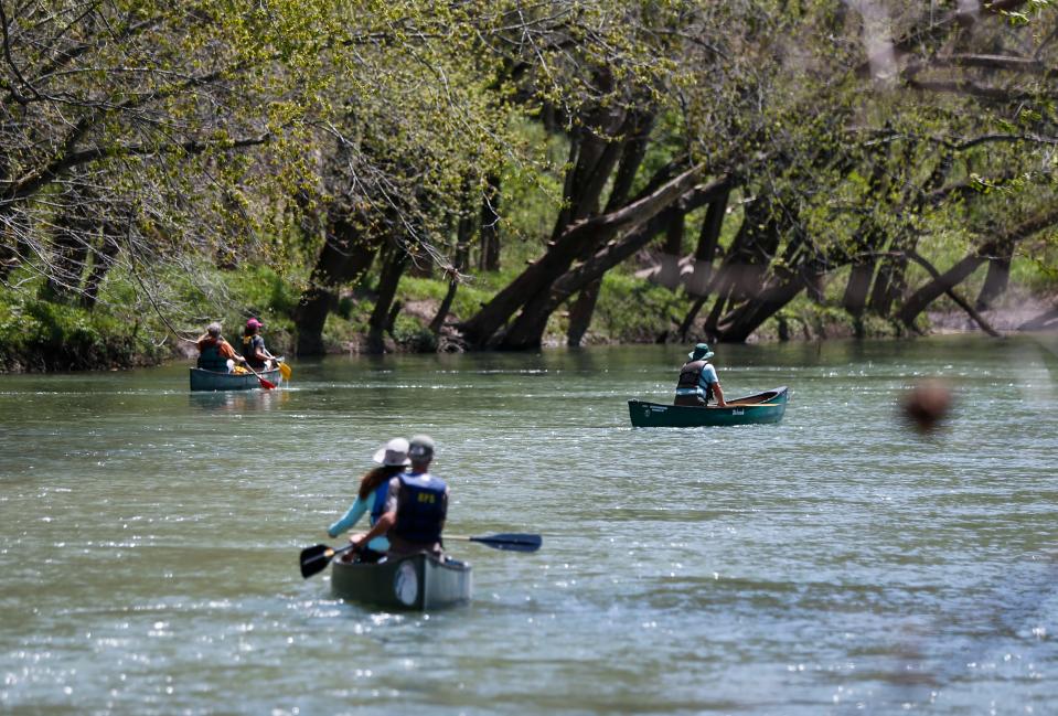 Volunteers in canoes paddle the James River as park of an Earth Day river cleanup on Friday, April 22, 2022. Nearly 100 volunteers took part in the cleanup put on by James River Basin Partnership, that included volunteers on foot picking up trash along Lake Springfield.