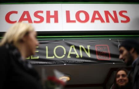 Pedestrians pass by a lending shop in northeast London October 3, 2013. REUTERS/Suzanne Plunkett