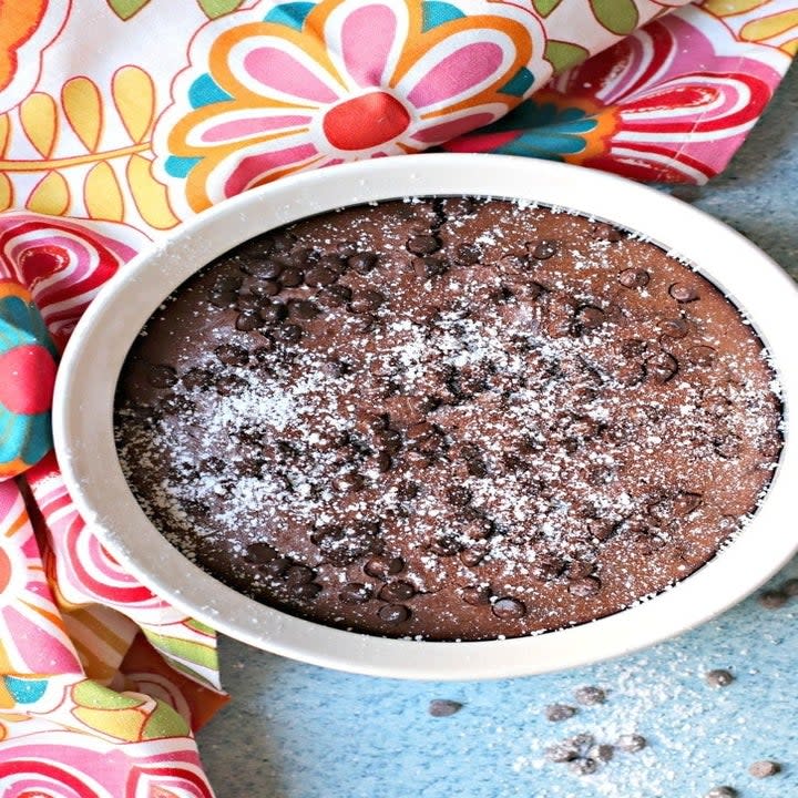 a bowl of brownies with chocolate chips and powdered sugar on top