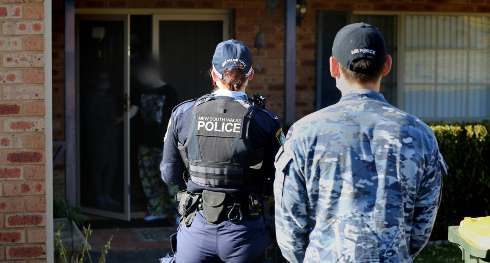 NSW Police and ADF stand in front of a home in western Sydney conducting COVID compliance checks in western Sydney. Source: NSW Police 