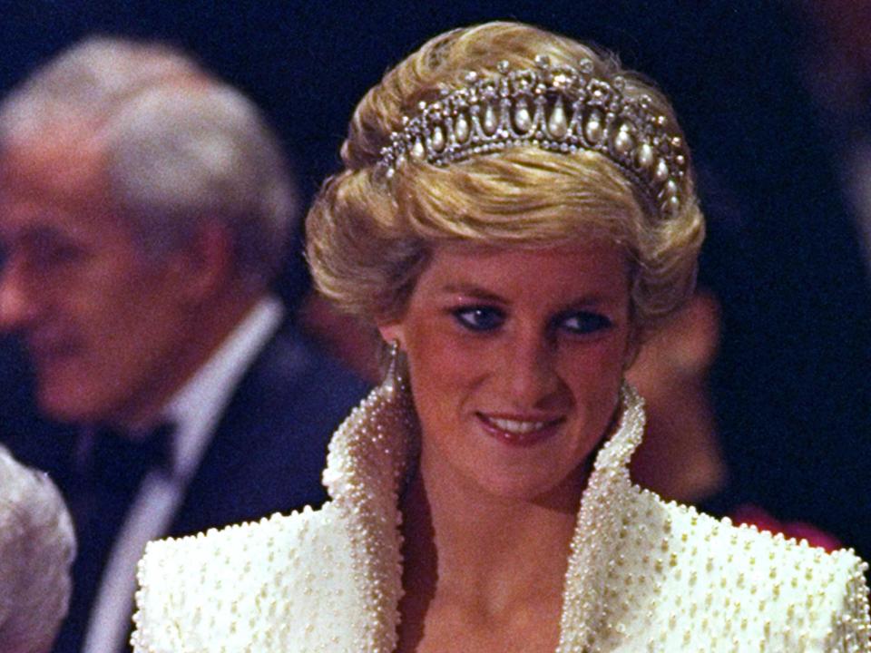 Princess Diana's "Elvis" outfit, wearing a white coat with a high collar