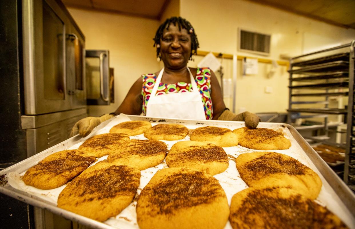 Elizabeth Kizito, owner of Kizito Cookies, pulls a fresh batch of snickerdoodle cookies from the oven during a busy morning of baking. Aug. 1, 2019