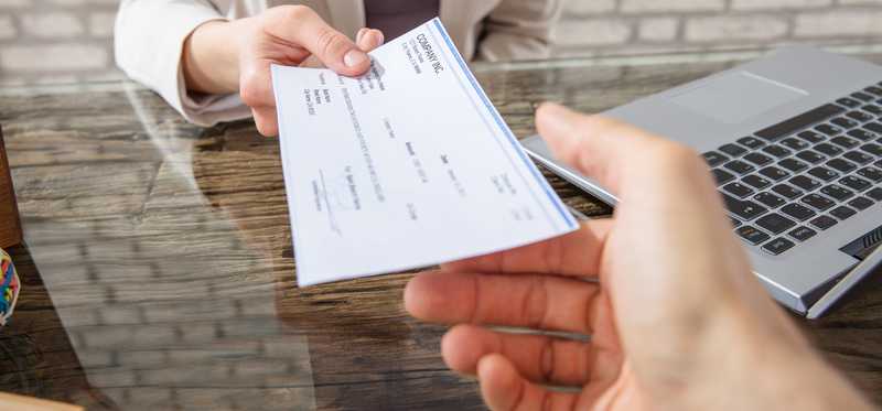 A person hands over a check.