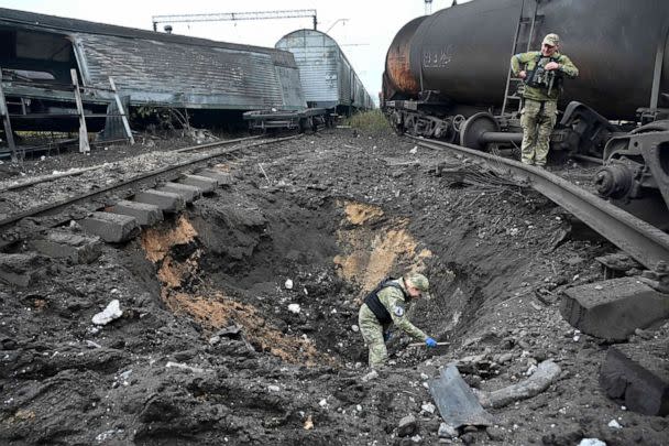 PHOTO: A forensic explosives expert examines a crater from a missile explosion at a freight railway station in Kharkiv, Sept. 21, 2022, amid Russia's military invasion on Ukraine.  (Sergey Bobok/AFP via Getty Images)