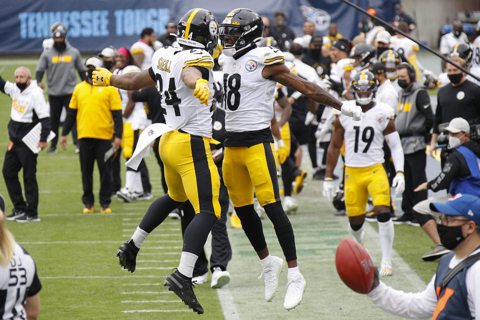 Benny Snell and Diontae Johnson bump chests in the air on the Steelers sideline. 