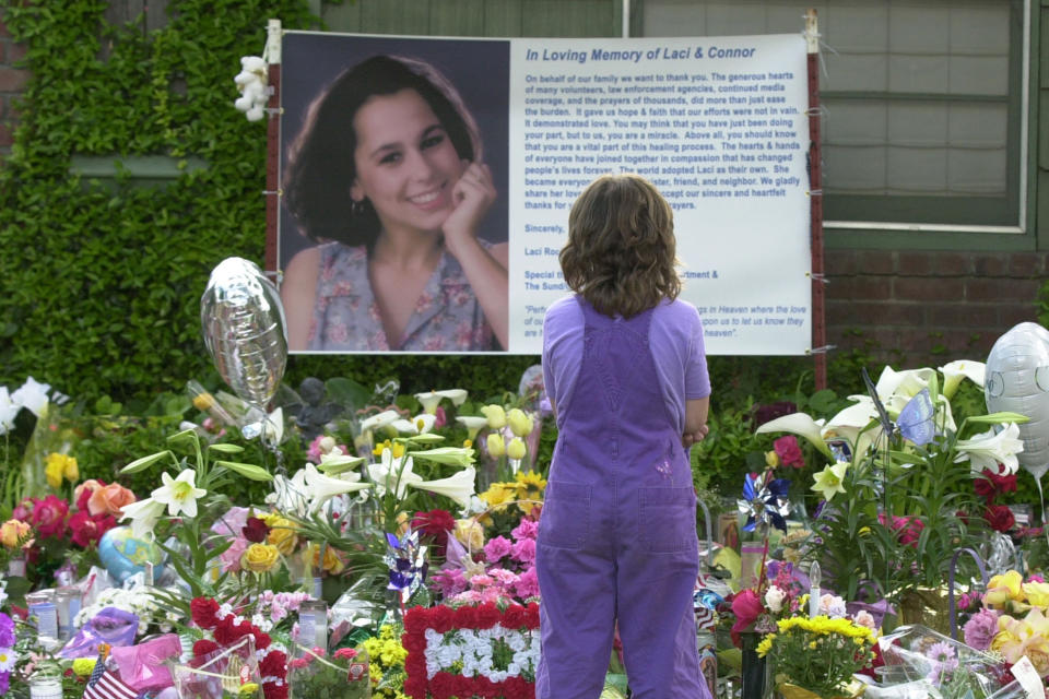 FILE - In this April 21, 2003 photo, Sarah Kellison stands in front of a memorial in honor of Laci Peterson outside the house Laci shared with her husband Scott Peterson in Modesto, Calif. Peterson's chance for a new trial in the murders of his pregnant wife and unborn son 20 years ago hinges on whether a California juror who helped send him to prison in 2004 amid worldwide publicity was biased because she was a domestic violence victim. (AP Photo/Marcio Jose Sanchez, File)