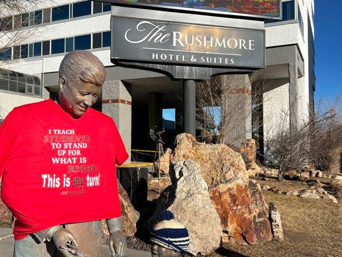 An opponant of South Dakota's social studies standards placed a T-shirt on the statue of President John F. Kennedy outside the Rushmore Hotel in Rapid City prior to a public hearing about the standards on Friday, Feb. 10, 2023.