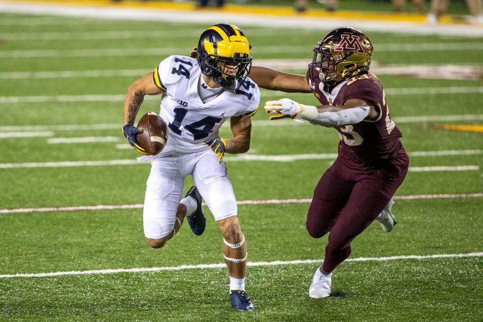 Michigan receiver Roman Wilson runs after catching a pass as Minnesota defensive back Jordan Howden attempts a tackle in the second half at TCF Bank Stadium, Oct. 24, 2020.