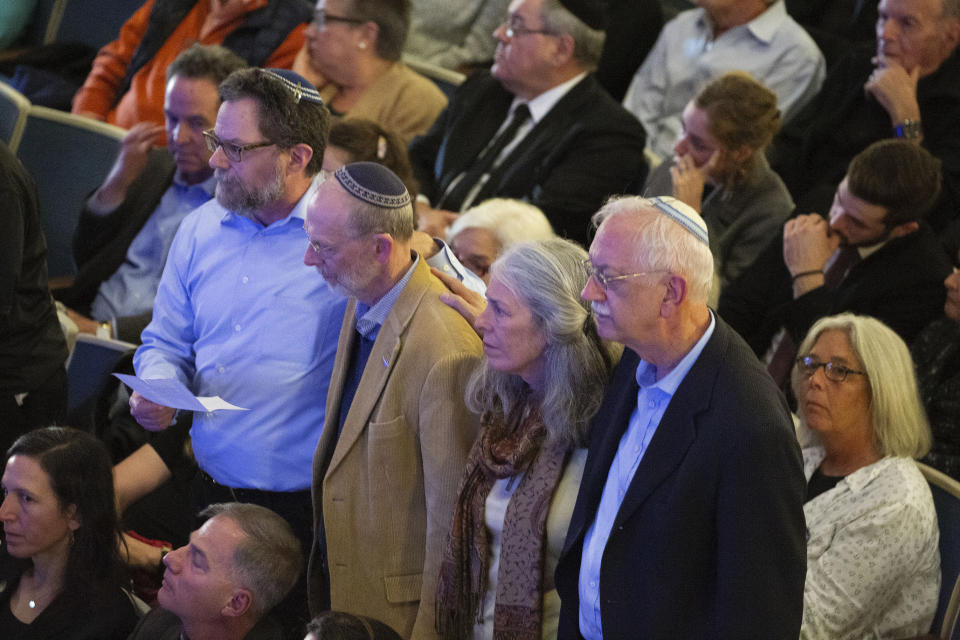 Survivors of the Tree of Life synagogue shooting stand during the one-year commemoration of the Tree of Life synagogue attack at Soldiers & Sailors Memorial Hall and Museum, Sunday, Oct. 27, 2019, in Pittsburgh. A year ago, a gunman entered the Tree of Life synagogue and killed 11 members of three congregations, Dor Hadash, New Light and Tree of Life/Or L'Simcha, holding Shabbat services in the building. (AP Photo/Rebecca Droke)