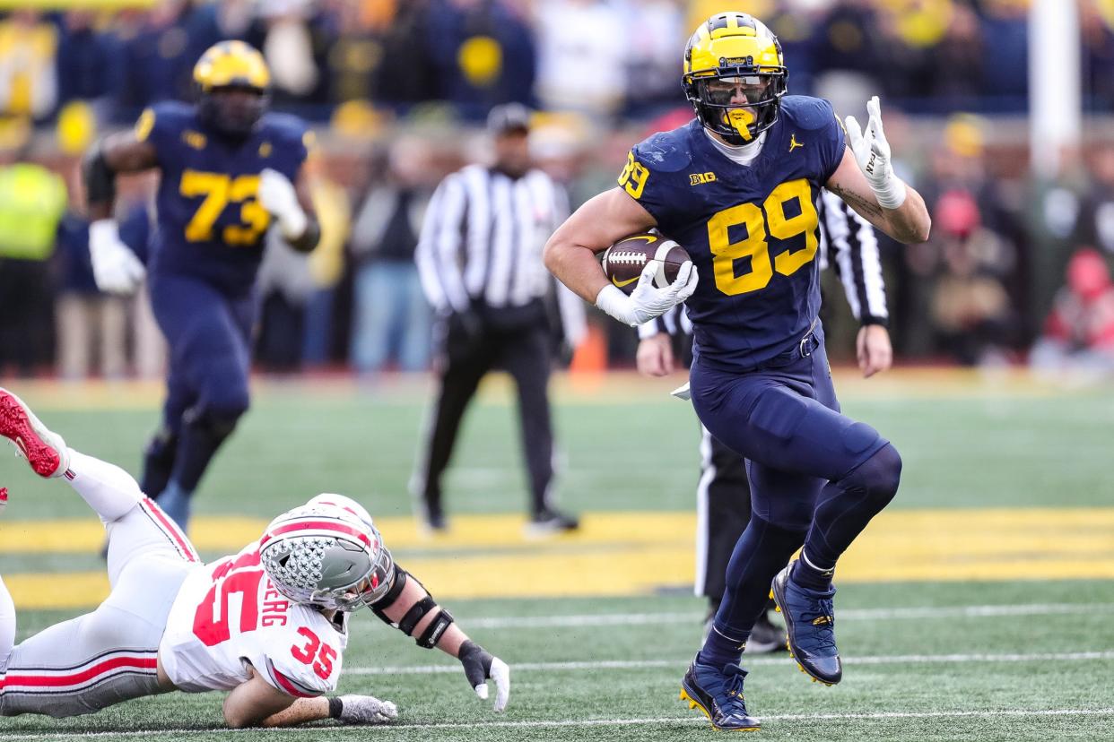 Michigan tight end AJ Barner runs past Ohio State linebacker Tommy Eichenberg during the second half at Michigan Stadium in Ann Arbor on Saturday, Nov. 25, 2023.