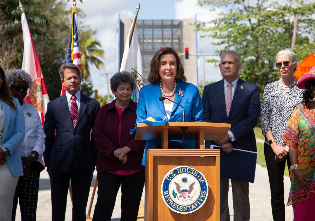 U.S. House Speaker Nancy Pelosi speaks Saturday as she stands in front of the George Bush Bridge in Delray Beach, which is frozen in the upright position. Pelosi said money from the infrastructure law could be used to repair the bridge.