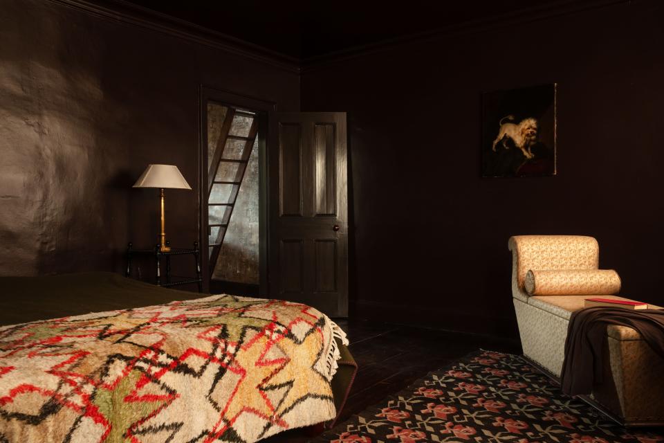 The bedroom features an Irish-wool blanket by Gallacher, an antique chaise longue upholstered in a Fortuny fabric, and An 18th-Century painting of a Maltichon; lamp by Jamb.