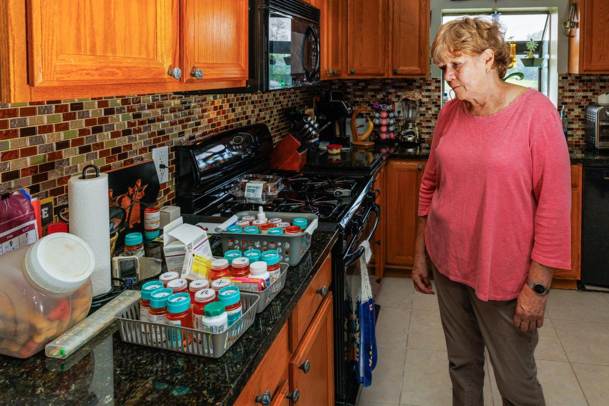 Wendy Jones looks over the collection of medicine needed to aid her husband and herself.