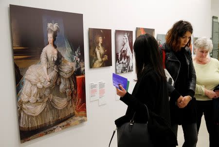 Visitors look at prints of powerful women throughout history in the "Women Fashion Power exhibition at the Design Museum in London November 4, 2014. REUTERS/Suzanne Plunkett
