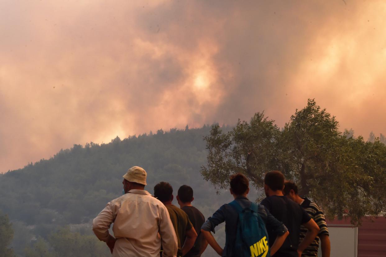 Locals view a wildfire near the village Vlyhada near Athens (Getty Images)