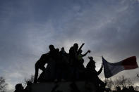 Protesters climb on a statue during a demonstration Tuesday, Dec. 10, 2019 in Paris. French airport employees, teachers and other workers joined nationwide strikes Tuesday as unions cranked up pressure on the government to scrap upcoming changes to the country's national retirement system. (AP Photo/Thibault Camus)