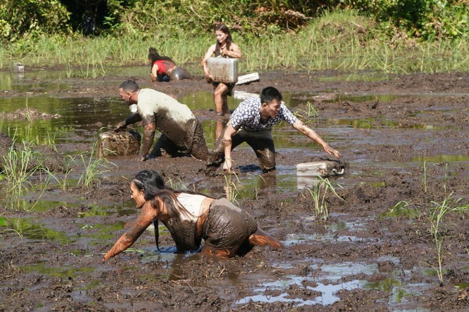 Miranda Harrison of Fort Myers (front) wades through mud with other players to snag briefcases full of money in the first episode of new NBC reality TV show "Deal or No Deal Island."