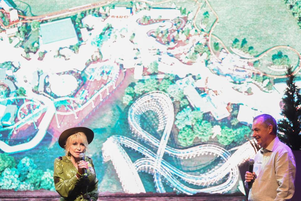 Dolly Parton and Dollywood president Eugene Naughton reveal plans for Big Bear Mountain on Friday. The $25 million roller coaster will be built in the Wildwood Grove section of Dollywood, and a rendering is displayed behind them.