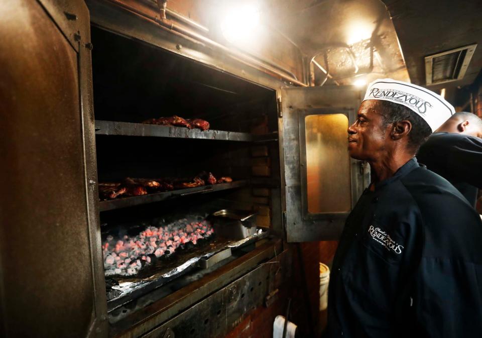 Henry Morris looks inside the fire pit at The Rendezvous in Downtown Memphis on Sept. 26, 2023. The charbroiled ribs at The Rendezvous are world-famous. The restaurant is celebrating its 75th anniversary this year.