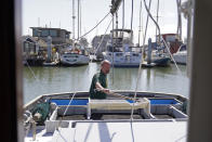 Salmon fisherman Mike Hudson works on the back of his boat at the Berkeley, Calif., Marina on Thursday, July 22, 2021. Baby salmon are dying by the thousands in one river and an entire run of endangered salmon could be wiped out in another. The plummeting catch has led to skyrocketing retail prices for salmon, hurting customers who say they can no longer afford the $35 per pound of fish, said Hudson, who has spent the last 25 years catching and selling salmon at farmers' markets in Berkeley. (AP Photo/Eric Risberg)