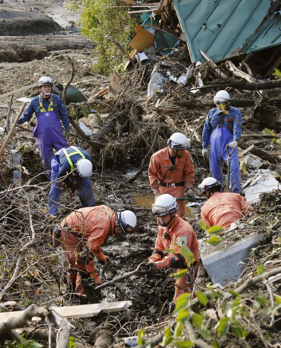 Firefighters search for missing people among collapsed houses following a landslide caused by Typhoon Wipha on Izu Oshima island, south of Tokyo, in this photo taken by Kyodo October 16, 2013. A typhoon killed 17 people in Japan on Wednesday, most on an offshore island, but largely spared the capital and caused no new disaster as it brushed by the wrecked Fukushima nuclear power station, the plant's operator said. (REUTERS/Kyodo)