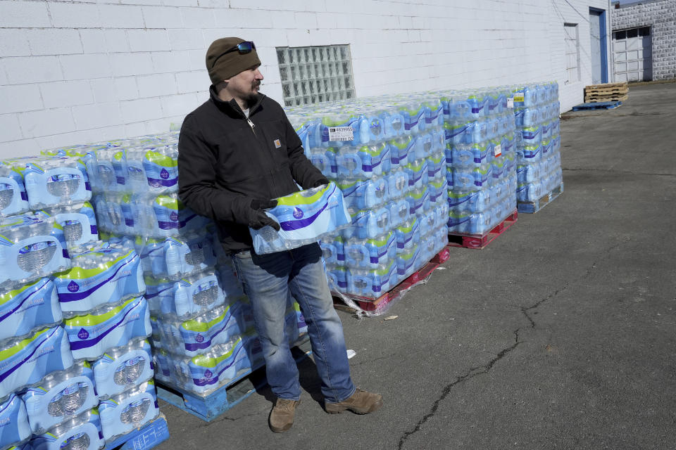 Volunteer Cory Brittain prepares to hand out free water in East Palestine, Ohio, as cleanup from the Feb. 3 Norfolk Southern train derailment continues, Friday, Feb. 24, 2023. (AP Photo/Matt Freed)