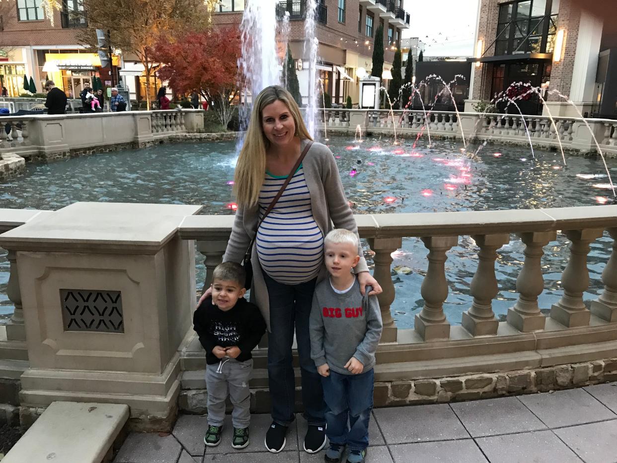 Woman pregnant with twins and with two little boys