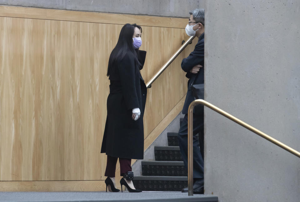 Chief Financial Officer of Huawei, Meng Wanzhou, left, is seen with a bandaged middle finger and hand during a break from a hearing at British Columbia Supreme Court, in Vancouver, British Columbia, Friday, March 19, 2021. (Darryl Dyck/The Canadian Press via AP)