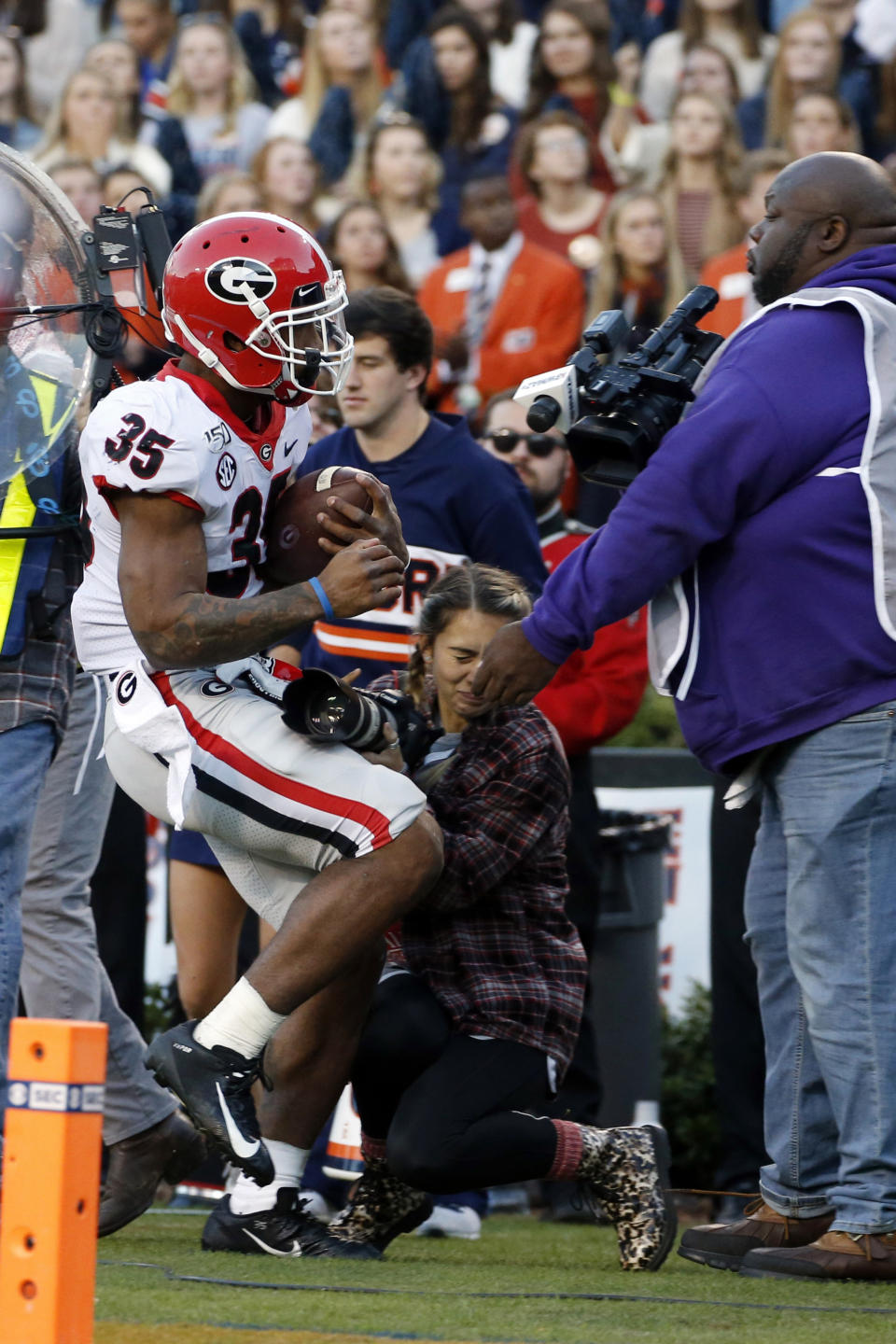 Georgia running back Brian Herrien (35) runs out of bounds and into a photographer during the first half of an NCAA college football game against Auburn, Saturday, Nov. 16, 2019, in Auburn, Ala. (AP Photo/Butch Dill)