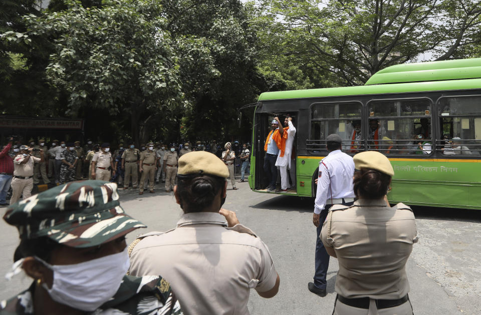 Indian policemen stand guard as farmers arrive at a protest site to hold a mock farmer's parliament in New Delhi, India, Thursday, July 22, 2021. More than 200 farmers on Thursday began a protest near India's Parliament to mark eight months of their agitation against new agricultural laws that they say will devastate their income. (AP Photo/Manish Swarup)