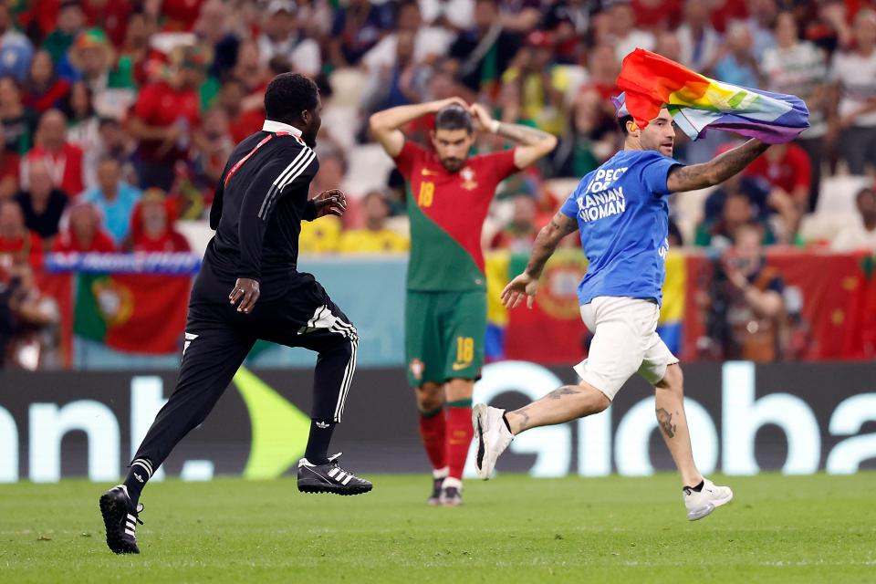 A spectator runs onto the pitch during the second half of the group stage match between Portugal and Uruguay  in the 2022 World Cup at Lusail Stadium.