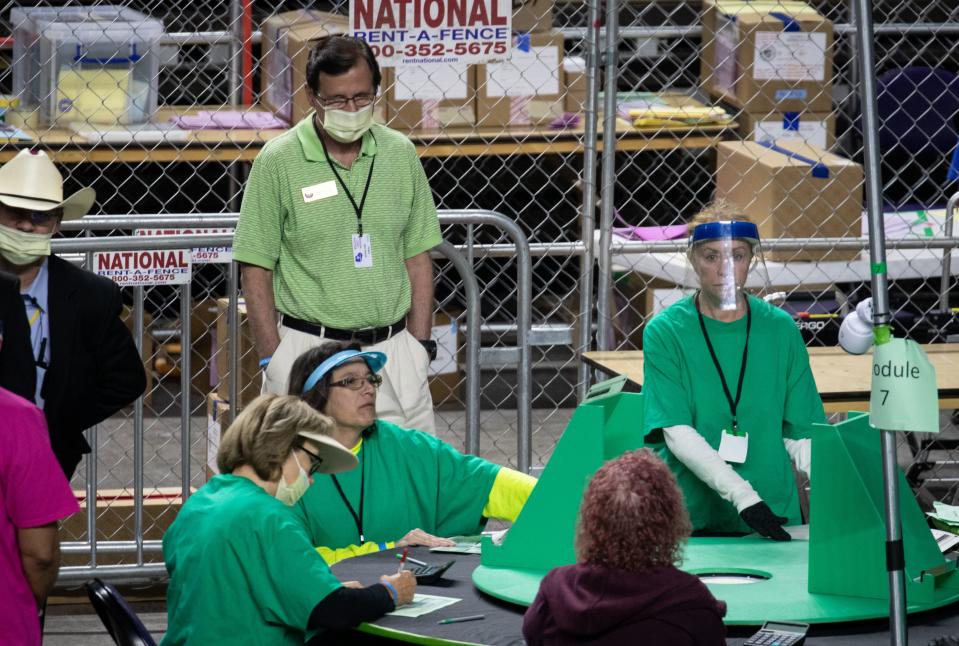 Wisconsin state Rep. Dave Murphy, in back, watches as Maricopa County ballots from the 2020 general election are examined and recounted by contractors hired by the Arizona Senate on June 12, 2021, at Veterans Memorial Coliseum, Phoenix, Arizona.