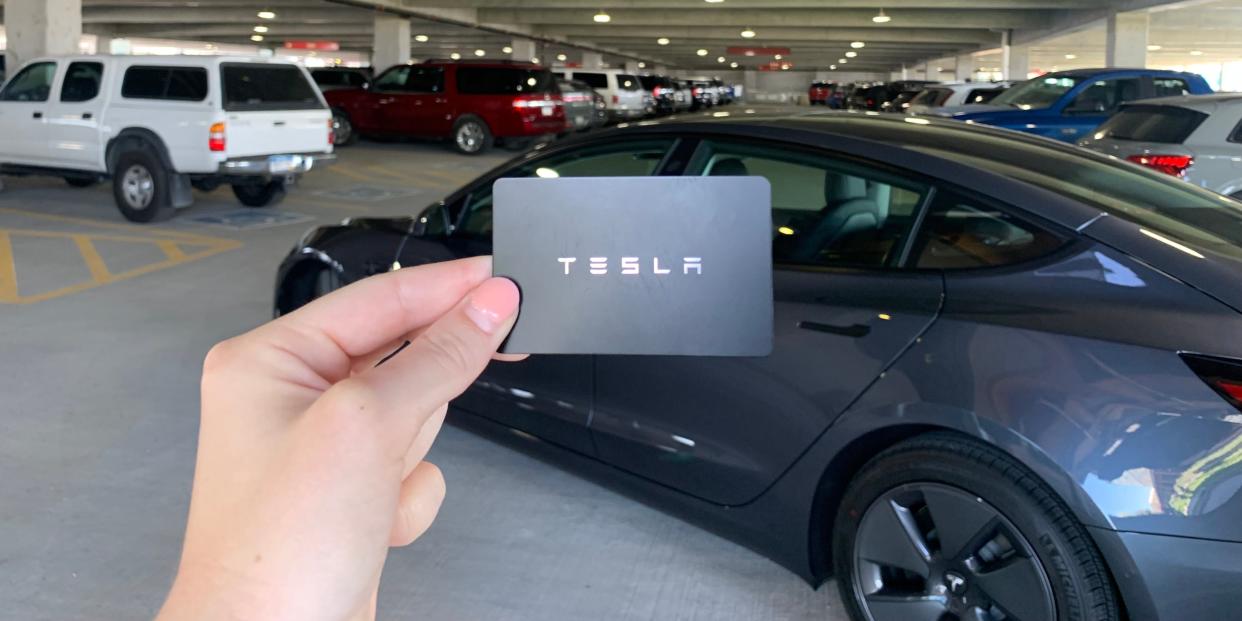 Individual holding a Tesla key card