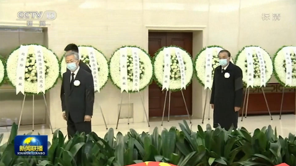 In this image taken from video footage run by China's CCTV, Chinese former president Hu Jintao, left, and Chinese Premier Li Keqiang, right, walk by remain of former president Jiang Zemin before sent for cremation at Babaoshan cemetery, at a military hospital in Beijing, Monday, Dec. 5, 2022. Chinese President Xi Jinping and other current and previous top officials paid their respects Monday to former leader Jiang Zemin, who died last week at age 96. (CCTV via AP)