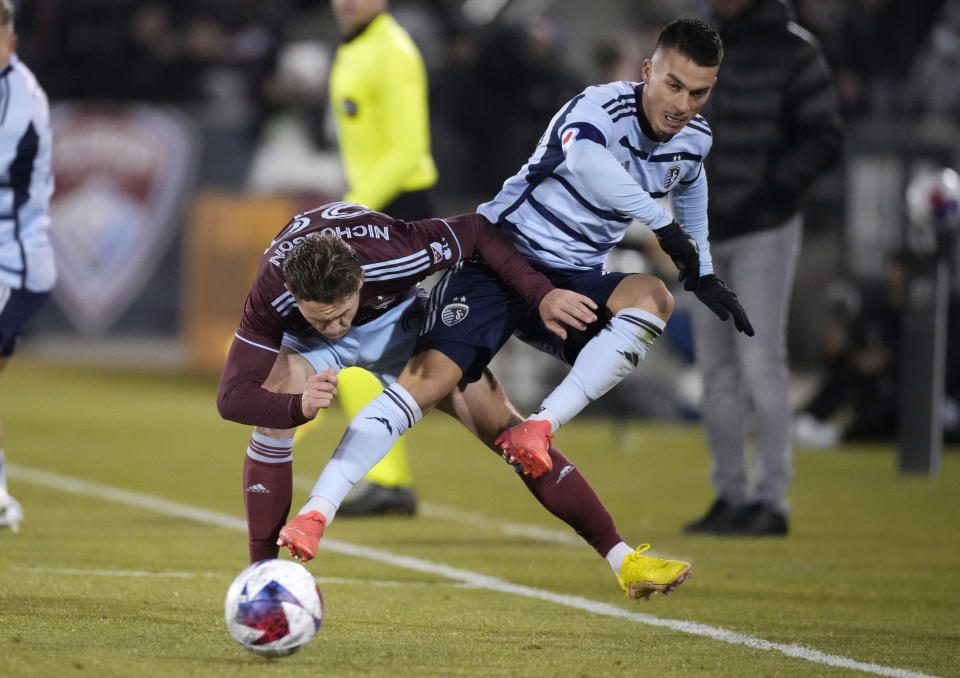 Colorado Rapids midfielder Sam Nicholson, left, and Sporting Kansas City midfielder Erik Thommy become entangled during the first half of an MLS soccer match Saturday, March 4, 2023, in Commerce City, Colo. (AP Photo/David Zalubowski)