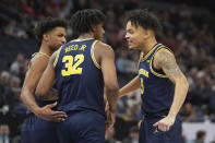 Michigan forward Tarris Reed Jr. (32) celebrates with guard Jace Howard, left, and forward Terrance Williams II (5) after making a basket while fouled during the first half of the team's NCAA college basketball game against Penn State in the first round of the Big Ten Conference men's tournament Wednesday, March 13, 2024, in Minneapolis. (AP Photo/Abbie Parr)